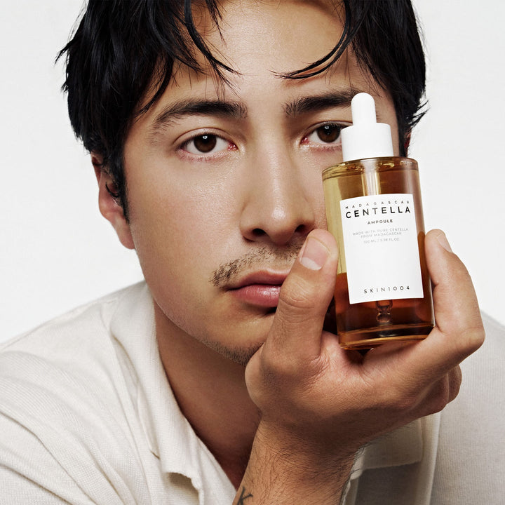 SKIN1004 Madagascar Centella Ampoule held beside the face of a model